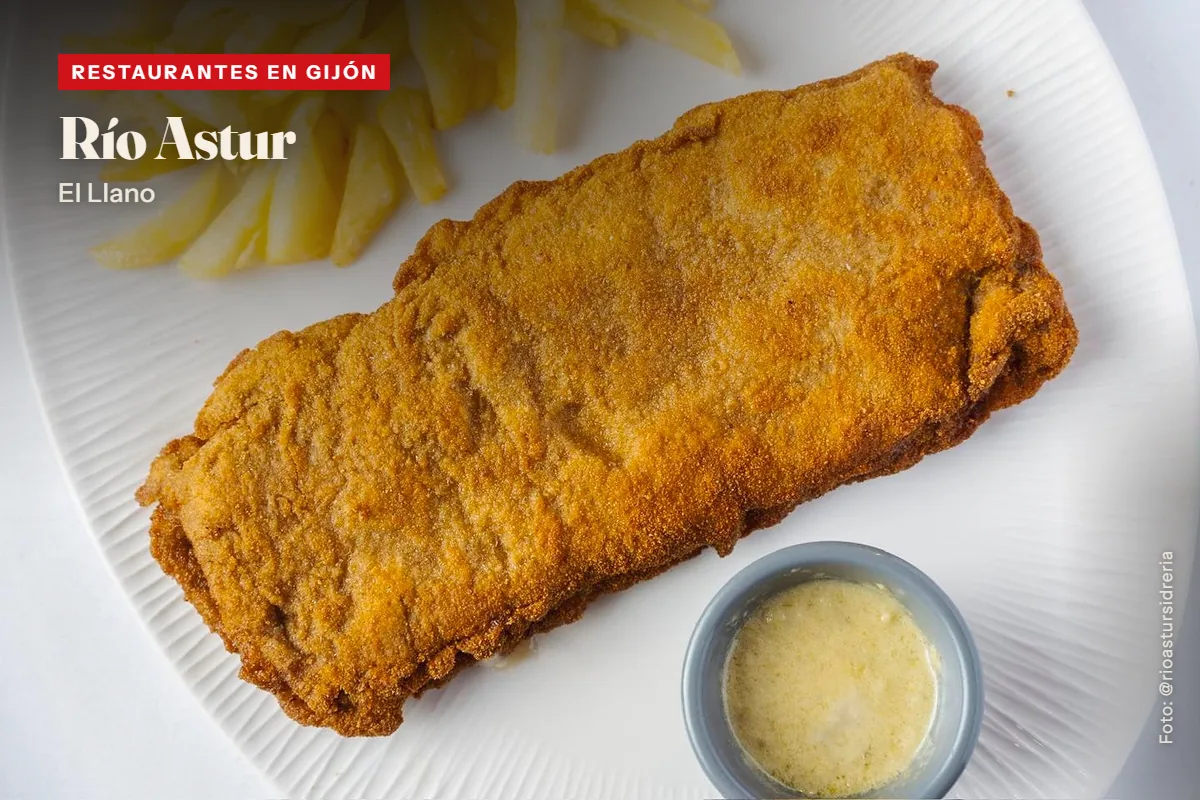 Cachopo de Río Astur, en Gijón, visto desde arriba en un plato blanco con patatas fritas y una salsera
