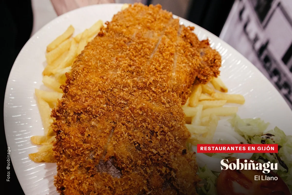 Cachopo de la Sidrería Sobiñagu, en Gijón, con rebozado crujiente, patatas fritas, ensalada y tomate